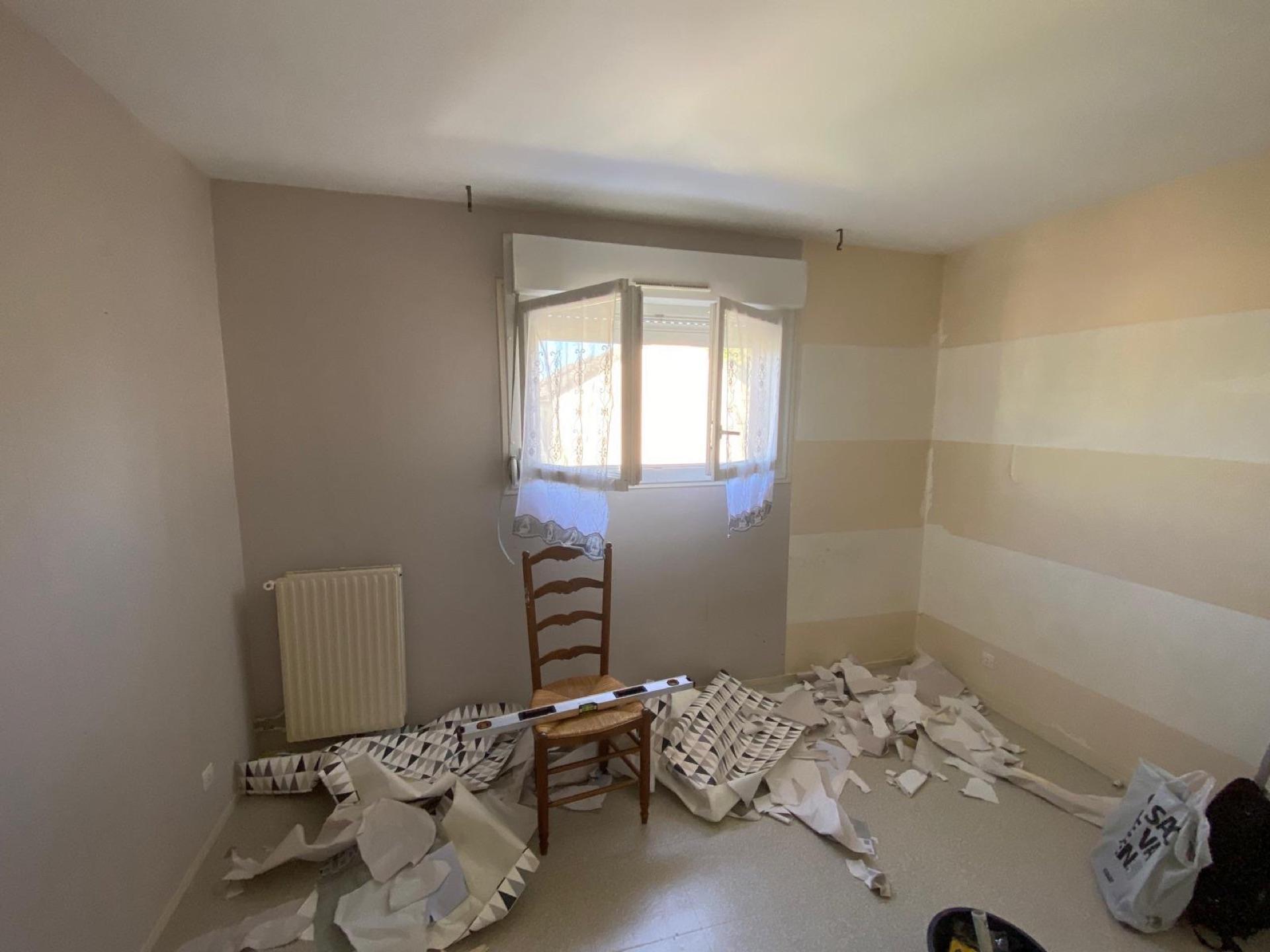 Préparation des murs d'une chambre avant mise en peinture : dépose de l'ancien revêtement