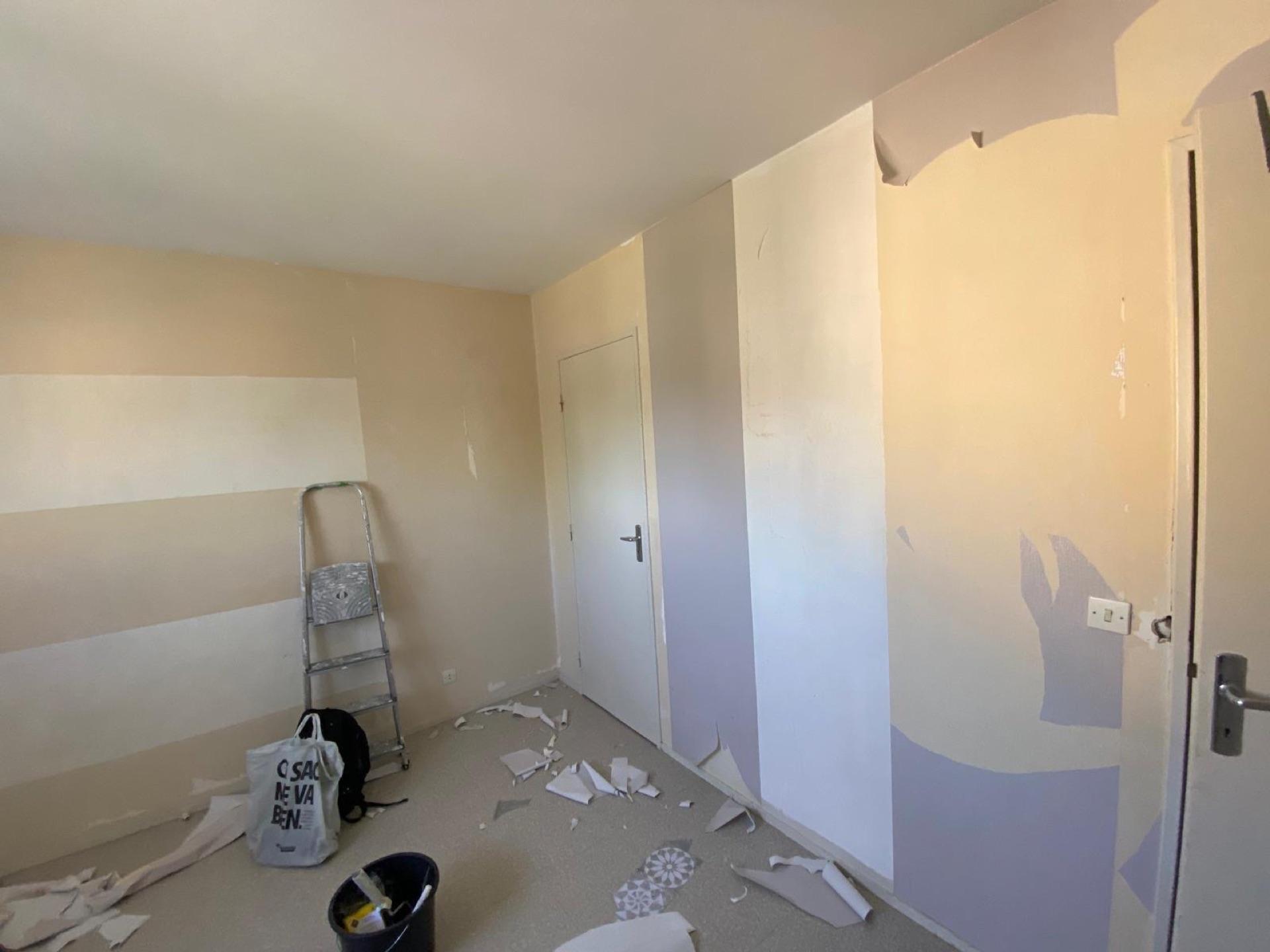 Dépose de l'ancien papier peint et préparation des supports avant rénovation d'une chambre