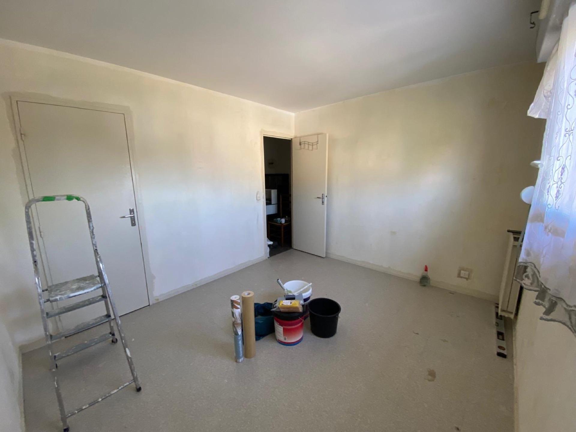 Chantier de mise en peinture d'une pièce : préparation, escabeau et pots de peinture