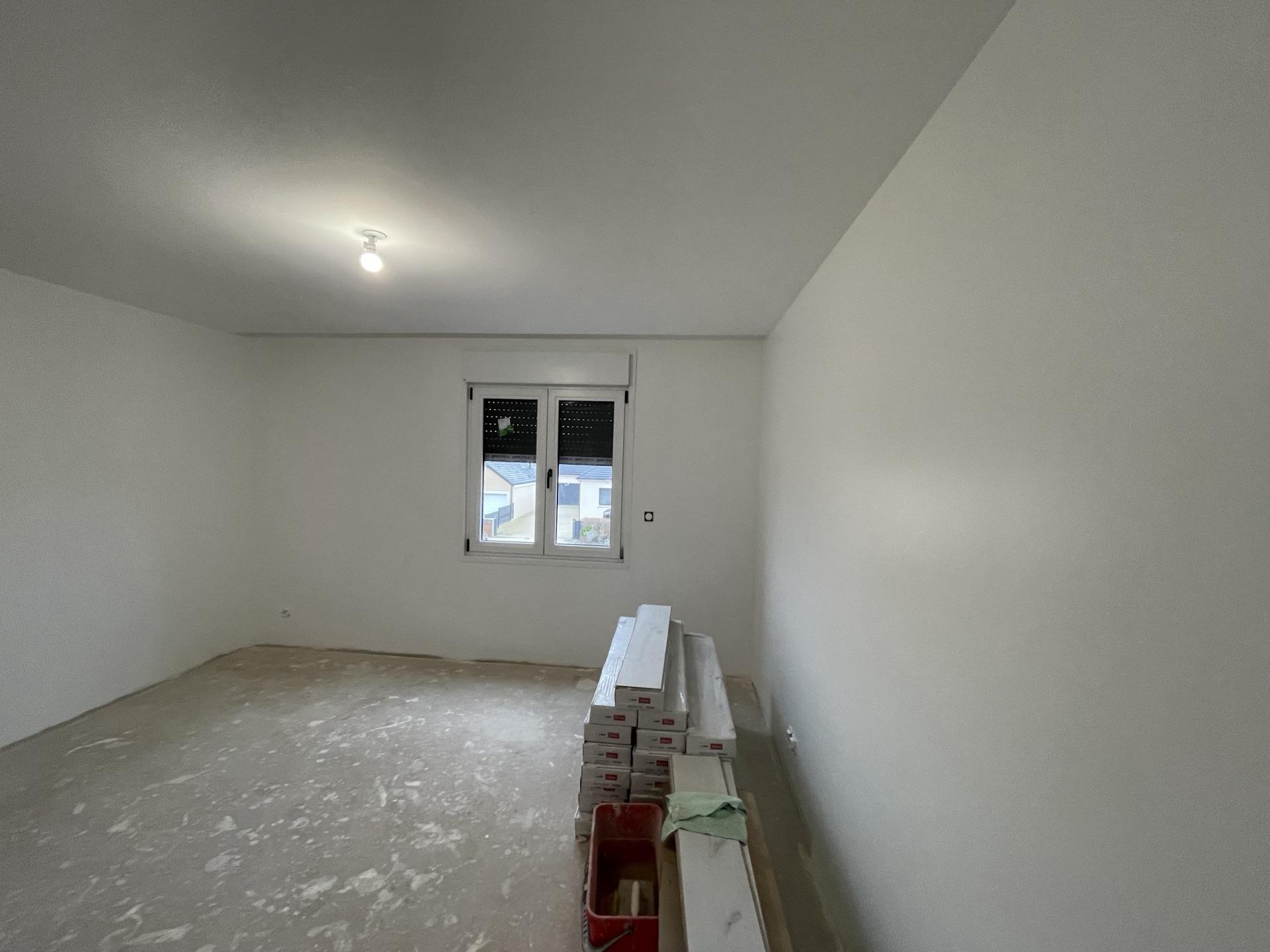 Pièce repeinte en blanc avec fenêtre, finition uniforme des murs et du plafond