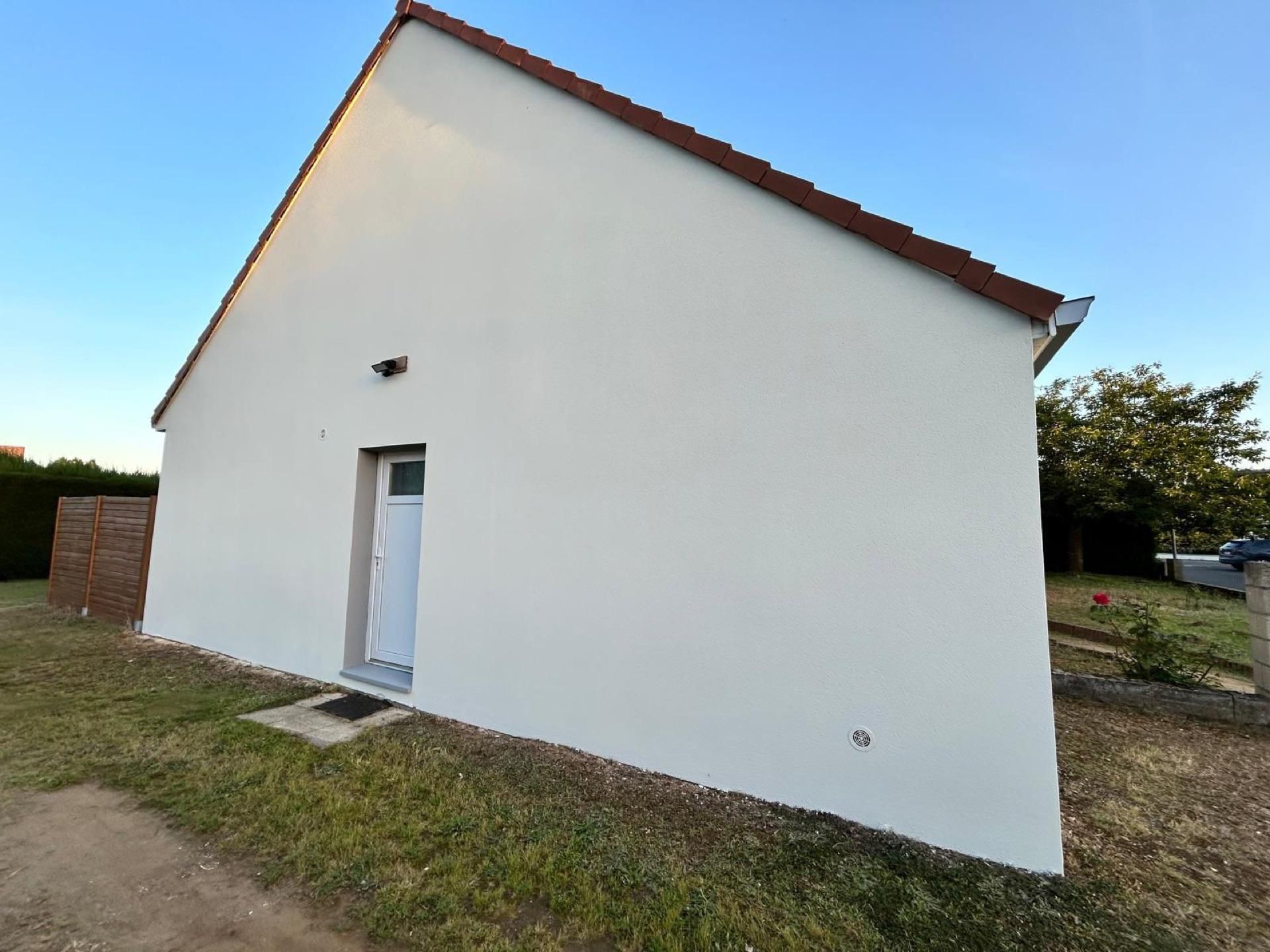 Pignon de maison en crépi blanc rénové, façade extérieure soignée par la Société Peinture Malas dans l'Orne